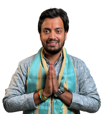 Man with a teal scarf in traditional Indian attire pressing palms together in a Namaste greeting, smiling at the camera.